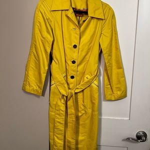 Tory Burch yellow belted trench raincoat with gold hardware.